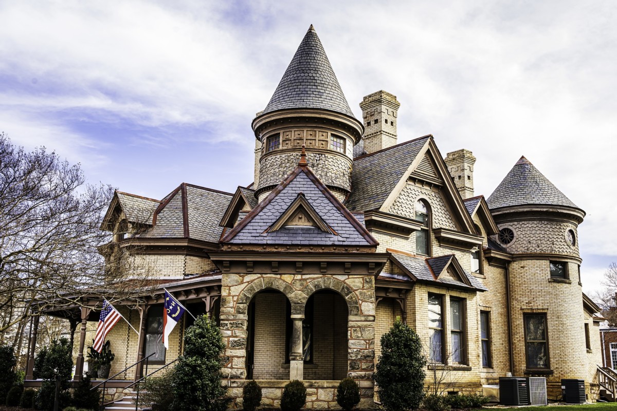 maison victorienne de style néo-roman avec un château à l'extérieur, des briques et des tourelles