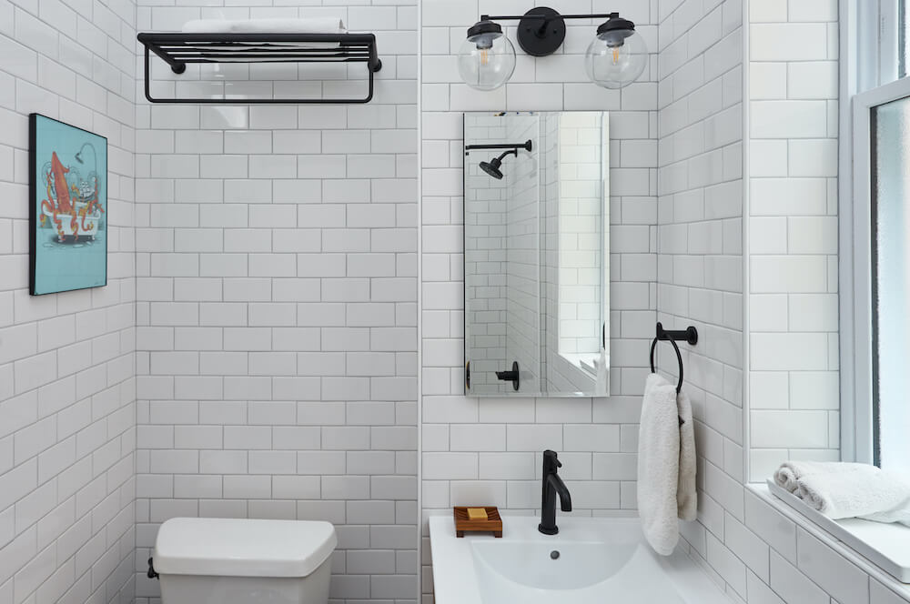 Salle de bain avec carrelage métro blanc et luminaires noirs mats