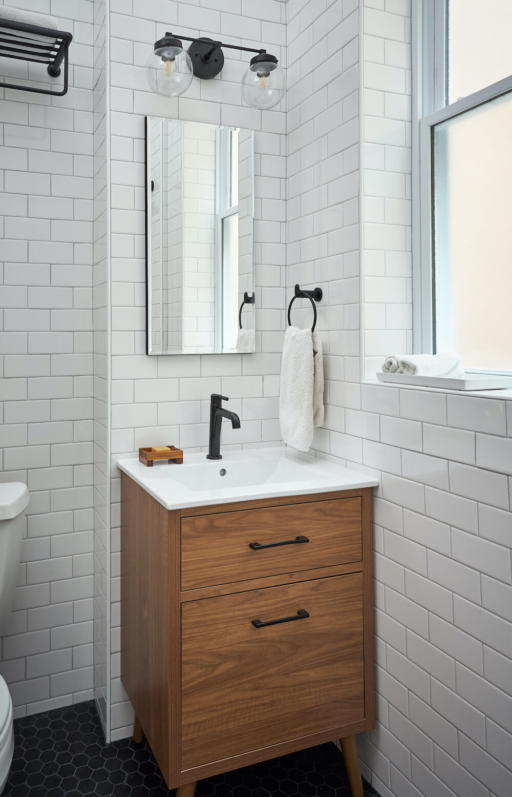 Salle de bain avec carrelage métro blanc et petite vanité en bois