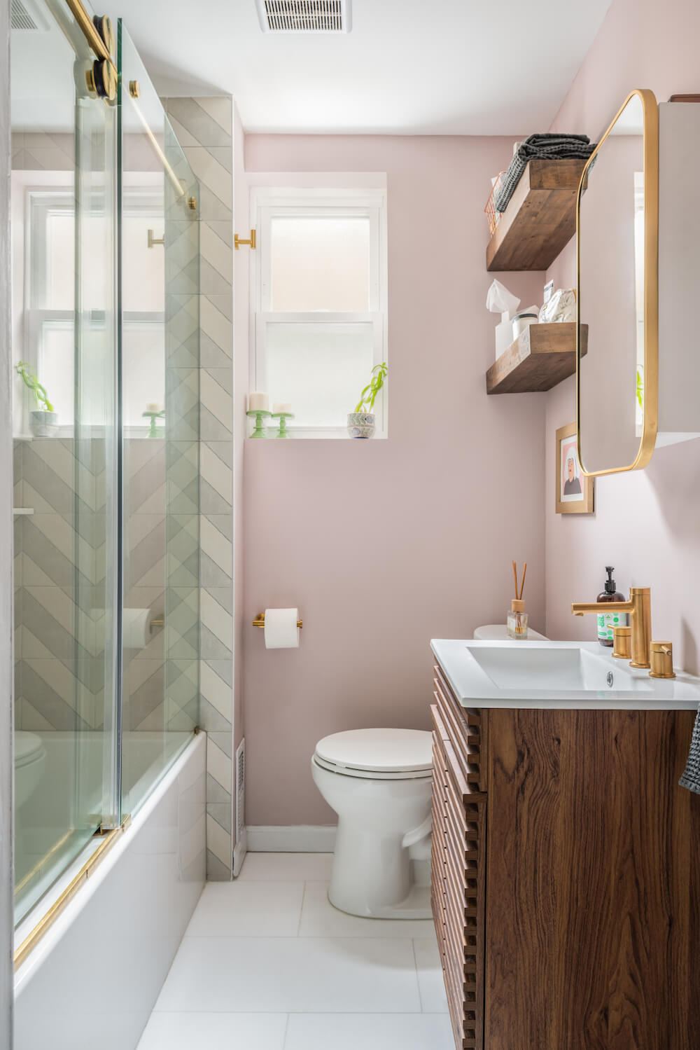 Salle de bain aux murs roses et vanité en bois