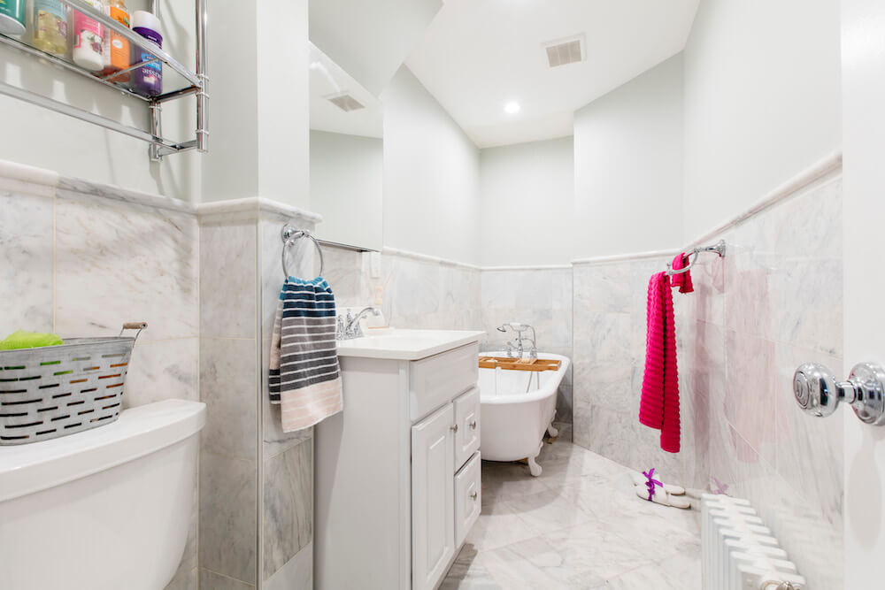 Salle de bain blanche avec vanité flottante et baignoire après rénovation