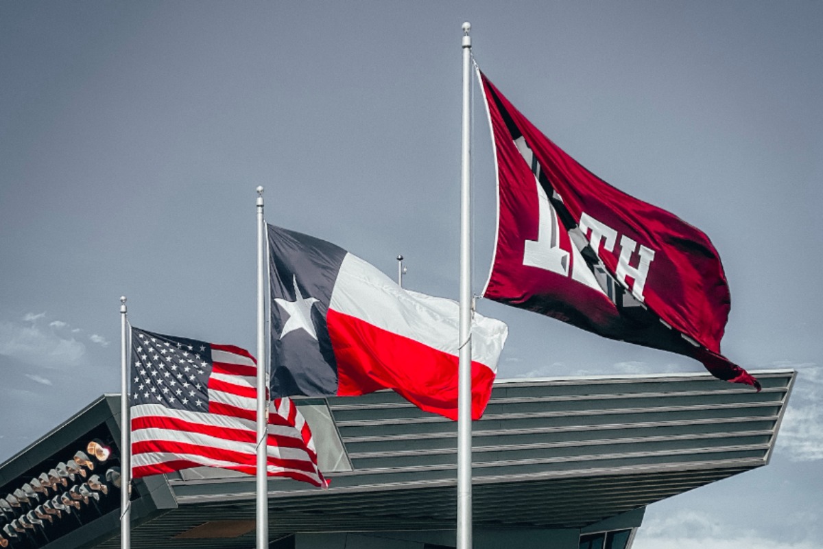 Trois drapeaux devant un stade